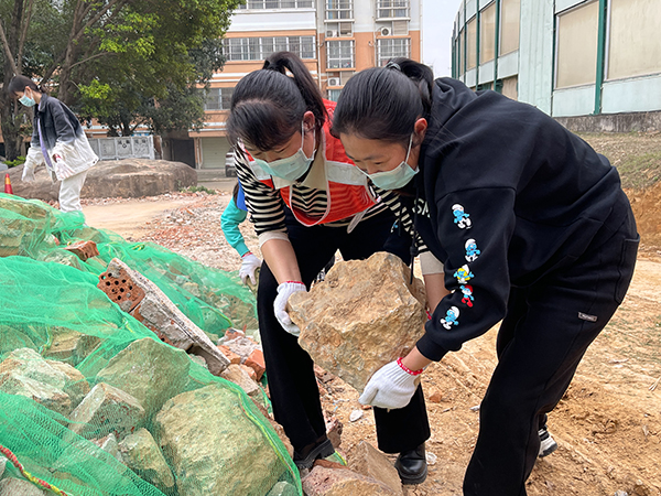 四队志愿者们携手清理路面美化大院环境 梁策 摄.jpg